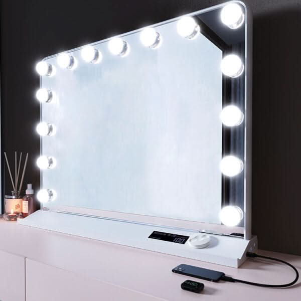 Standing LED makeup mirror with touch controls and bright bulbs on a vanity