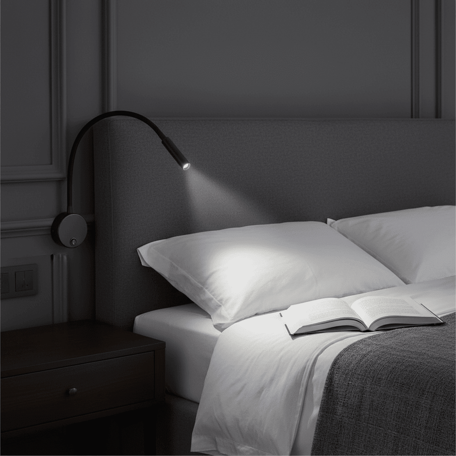 Black flexible LED reading light mounted beside a bed and aimed at an open book