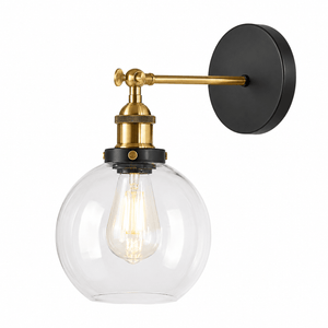 Antique brass wall light with clear glass globe, showcasing elegant design and warm illumination.