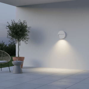 White LED wall light illuminating a patio with a potted plant and chair nearby.