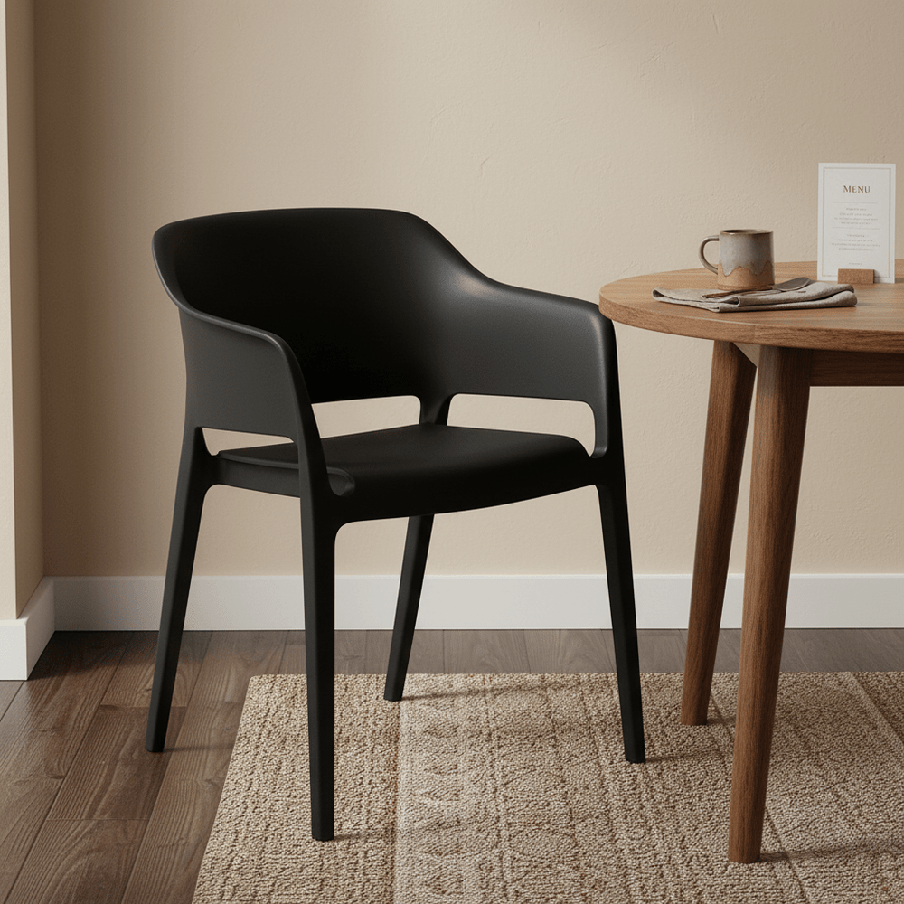 Solid stackable black chair beside a wooden table with a coffee cup and menu on it.