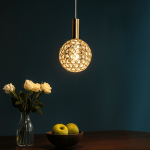 Pendant light labeled 'Emma' hanging above a table with flowers and apples.