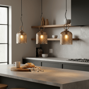 Three Chestnut Glass Pendants hanging above a kitchen island with a wooden cutting board and bread.