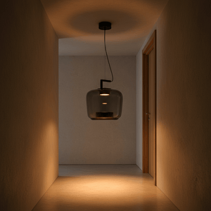 Green LED pendant light hanging in a softly lit hallway, casting warm light on the floor.