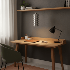 Aluminium pendant light hanging above a wooden desk with a green chair and decorative items.