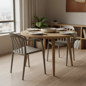 Warm grey dining chair positioned at a wooden table set for a meal, with a plant in the background.