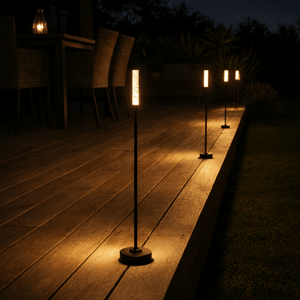 Outdoor pathway with illuminated standing lamps on a wooden deck at night.