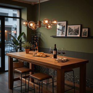 Stylish dining area featuring a six-light pendant with amber glass shades above a wooden table set with wine and cheese.