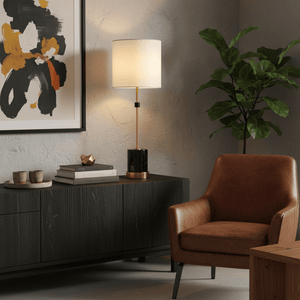 Stylish table lamp with a black and gold marble base on a dark console, surrounded by decor and a cozy chair.