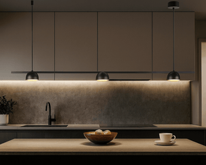Modern kitchen with a wooden island, bowl of fruit, and cup, featuring pendant lights.