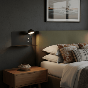 Stylish black USB wall light mounted beside a bed, casting a warm glow in a cozy bedroom setting.