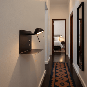 Black USB wall light mounted in a hallway, illuminating the space with a warm glow.