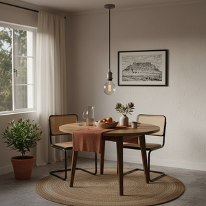 Metallic pendant light fixture with a bulb on a white background