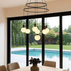 Modern dining room with a chandelier, table, chairs, and a view of a pool.