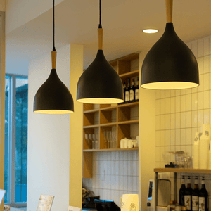 Modern interior of a cafe with pendant lights, shelves, and coffee-making equipment.