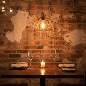 Stylish gold pendant light above a dining table set with plates and glasses, creating a warm ambiance.