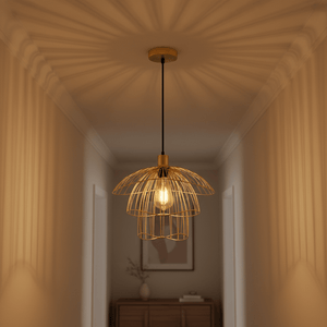 Stylish gold pendant light hanging in a softly lit hallway, casting intricate shadows.
