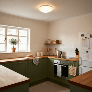 Modern kitchen with green cabinets, wooden countertops, and a frosted glass ceiling light.