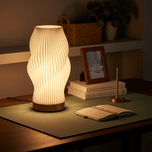 Dahlia 3D Printed Table Lamp on a desk, illuminating an open book and surrounded by decor.