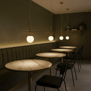 Stylish setting featuring multiple Catalina Duo Gold Pendant Lights above marble tables in a modern dining area.