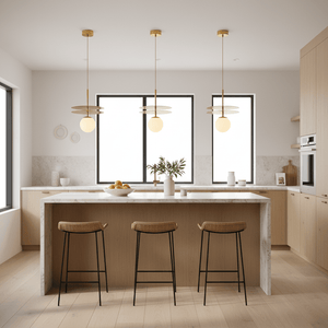 Three Catalina Duo Gold Pendant Lights hang above a modern kitchen island with a marble top and wooden cabinetry.