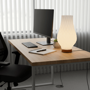 3D printed table lamp on a wooden desk beside a computer, with a notebook and pen.