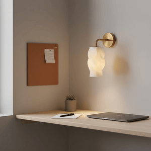 Dahlia 3D printed wall light illuminating a workspace with a cork board and potted plant.