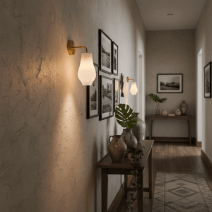 Stylish Bluebell wall light illuminating a hallway with framed photos and decorative vases.