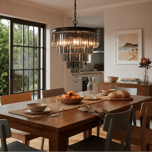 Elegant charcoal grey 5 tier crystal chandelier hanging above a wooden dining table set with fruit and bread.