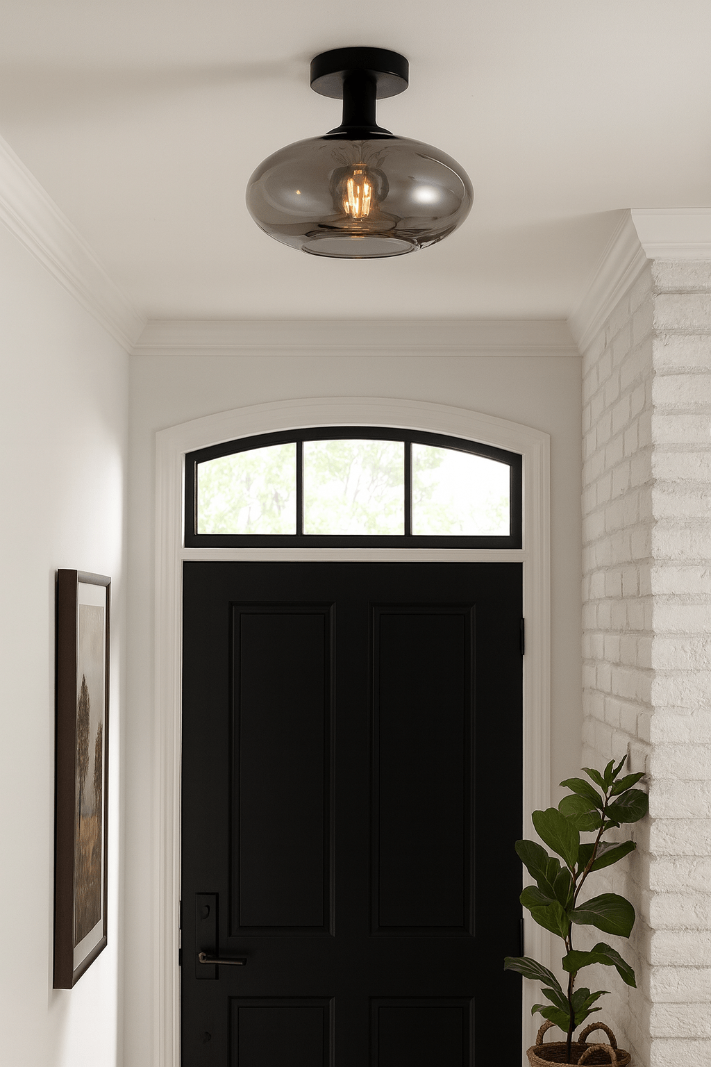Smokey orb ceiling light mounted in a stylish entrance hall with a black door and potted plant.
