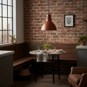 Industrial-style pendant light hanging above a rustic dining table set with dishes and plants.