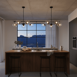 5-light pendant in black and antique brass above a wooden kitchen island, with a scenic view outside.