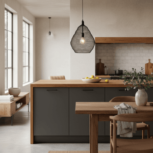 Phantom Black 500 Wire Mesh Pendant hanging over a kitchen island with wooden accents and a bowl of lemons.