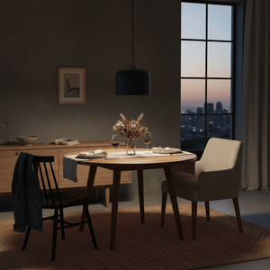 Stylish dark grey pendant light hanging over a wooden dining table set with wine glasses and decor.