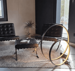 LED Crystal Ring Floor Lamp in a modern lounge setting with black chairs and a plant.