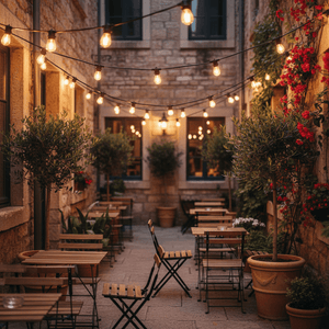 Outdoor patio scene with string lights overhead, wooden tables, and potted plants creating a warm ambiance.