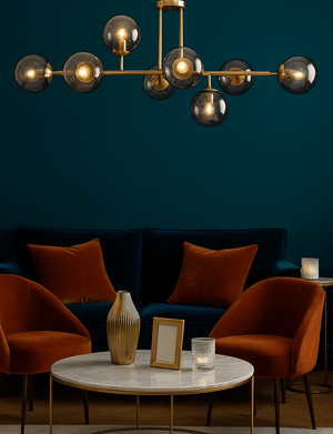 Modern living room with a chandelier, dark blue walls, and orange chairs.