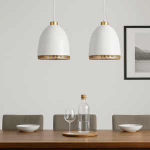 Two white pendant lights with gold accents hanging above a dining table.