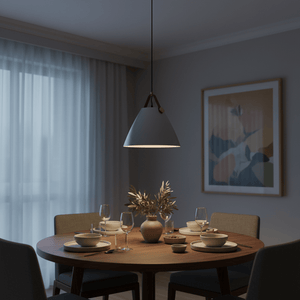 Grey cone pendant light with leather strap hanging above a set dining table