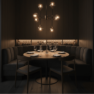 Elegant 8 light black and bronze chandelier illuminating a cozy dining area with a round table and plush seating.