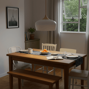 Scandinavian-style pendant light hanging above a dining table set with plates and fruit.