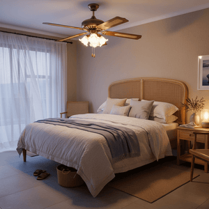 Rattan ceiling fan with light in a cozy bedroom, illuminating a neatly made bed with soft linens.