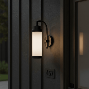 Kerala Wall Lamp in matt black finish mounted on a textured wall, illuminating the entrance area.