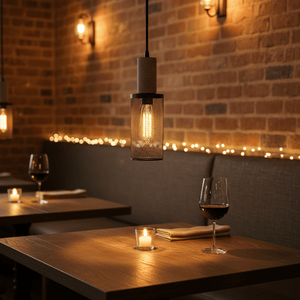 Midnight Long Mesh & Stone Pendant Light hanging over a dining table with warm ambiance, featuring a textured mesh shade.