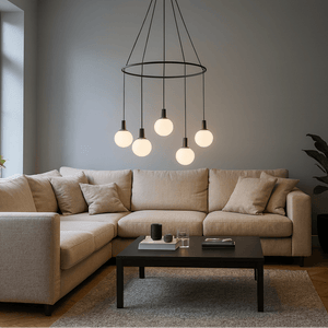 Modern living room with beige sectional sofa, dark coffee table, and pendant light fixture.