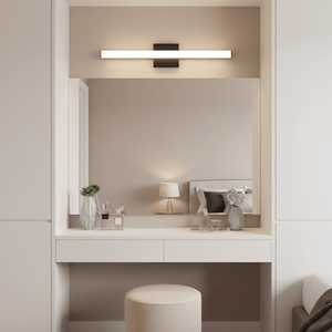 Sandy black LED light mounted above a mirror on a vanity with decor items.