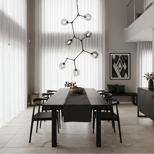 Vertical 7-light pendant in black with smoke glass, hanging over a modern dining table.