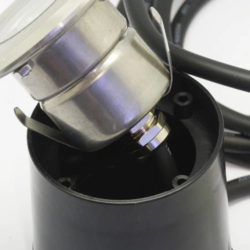 Stainless steel LED ground light with wiring, shown from side angle.