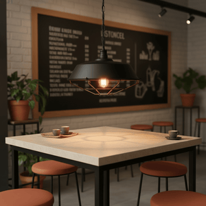 Black grid pendant light hanging over a modern dining table with orange stools, featuring a warm glow.
