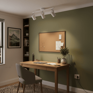 A stylish home office setup featuring a 3 light ceiling spotlight illuminating a wooden desk with a laptop and plants.